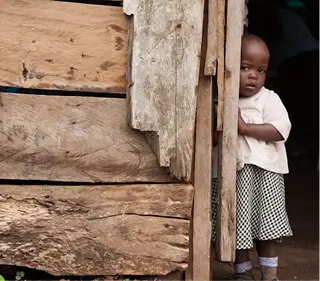A thirsty child standing by the door